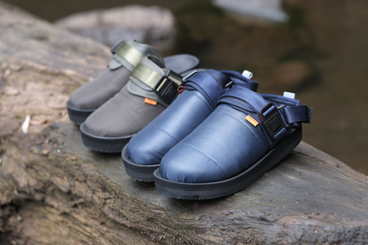 GRAKLU Artic Weave Outdoor Mule Sandals displayed alongside other colours on a log, perfect for outdoor adventures.