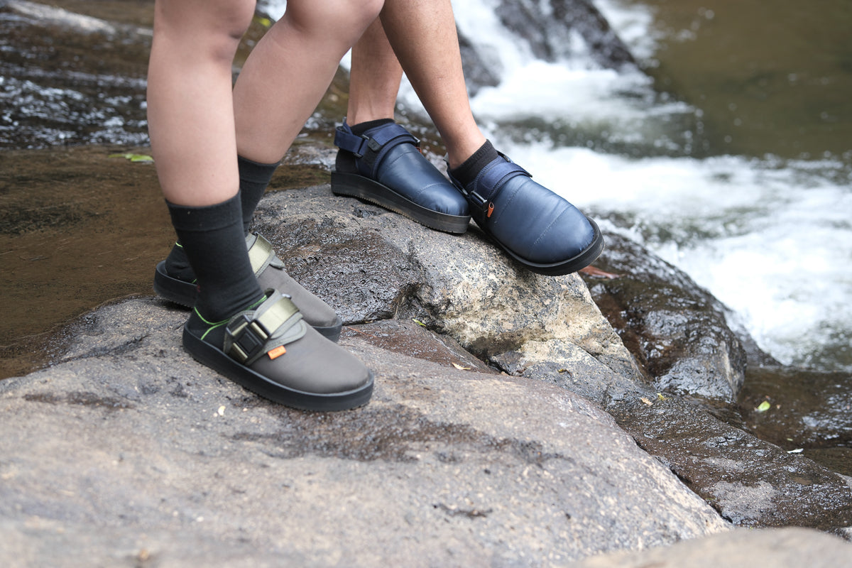 GRAKLU Artic Weave Outdoor Mule Sandals being worn by a person by a stream, emphasizing their water-resistant feature.