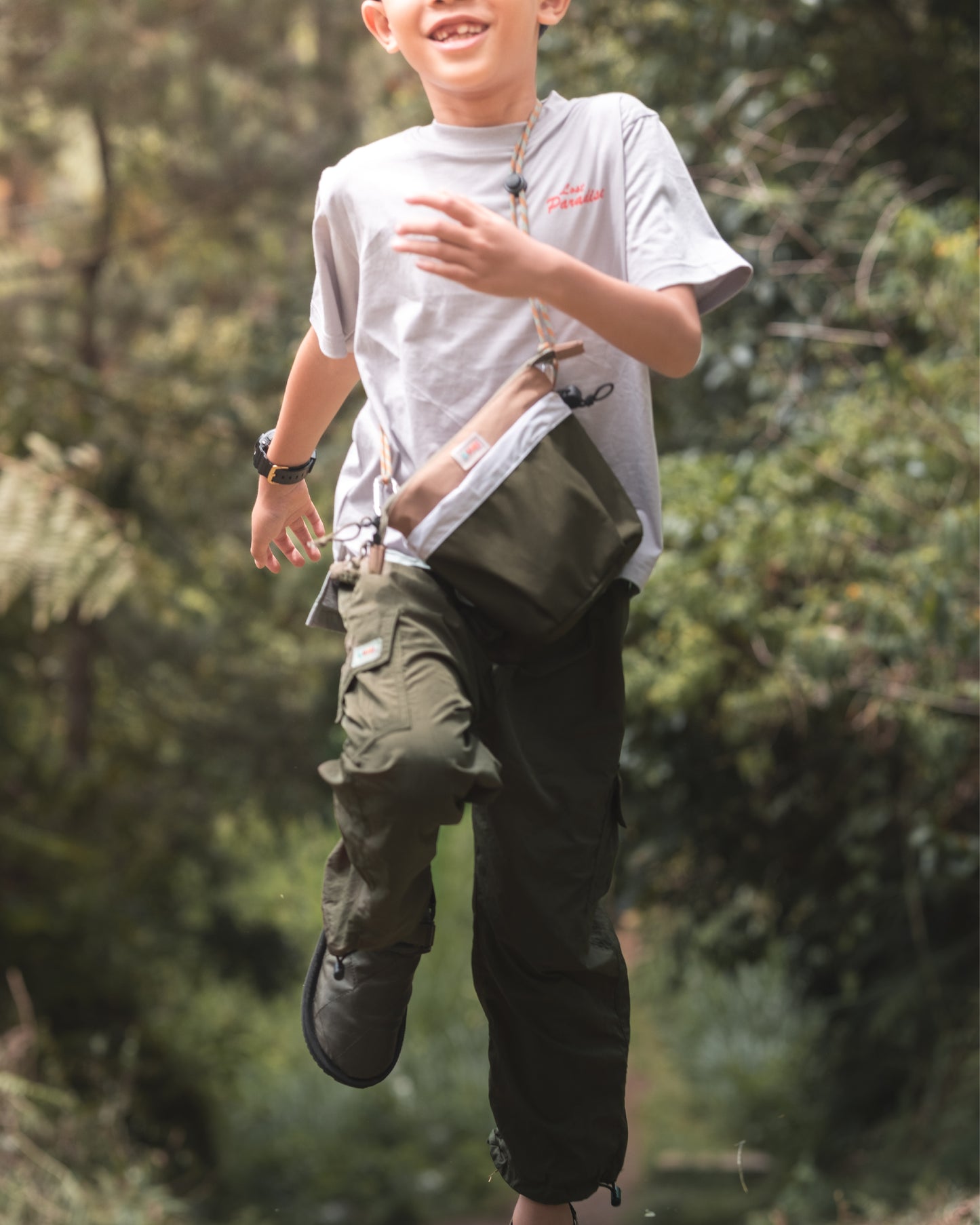 Child running outdoors with the PIXIES Nutty Sprout bag, emphasising playful adventure.