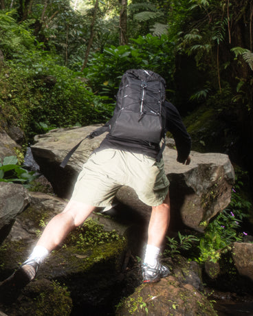 TREQ SHADOW Trail 22L Outdoor Backpack being used in a rugged outdoor setting, demonstrating its durability and style.