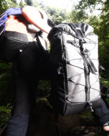 A user climbing with the TREQ WILDFLARE Trail 22L Outdoor Backpack, demonstrating its suitability for rugged outdoor environments.