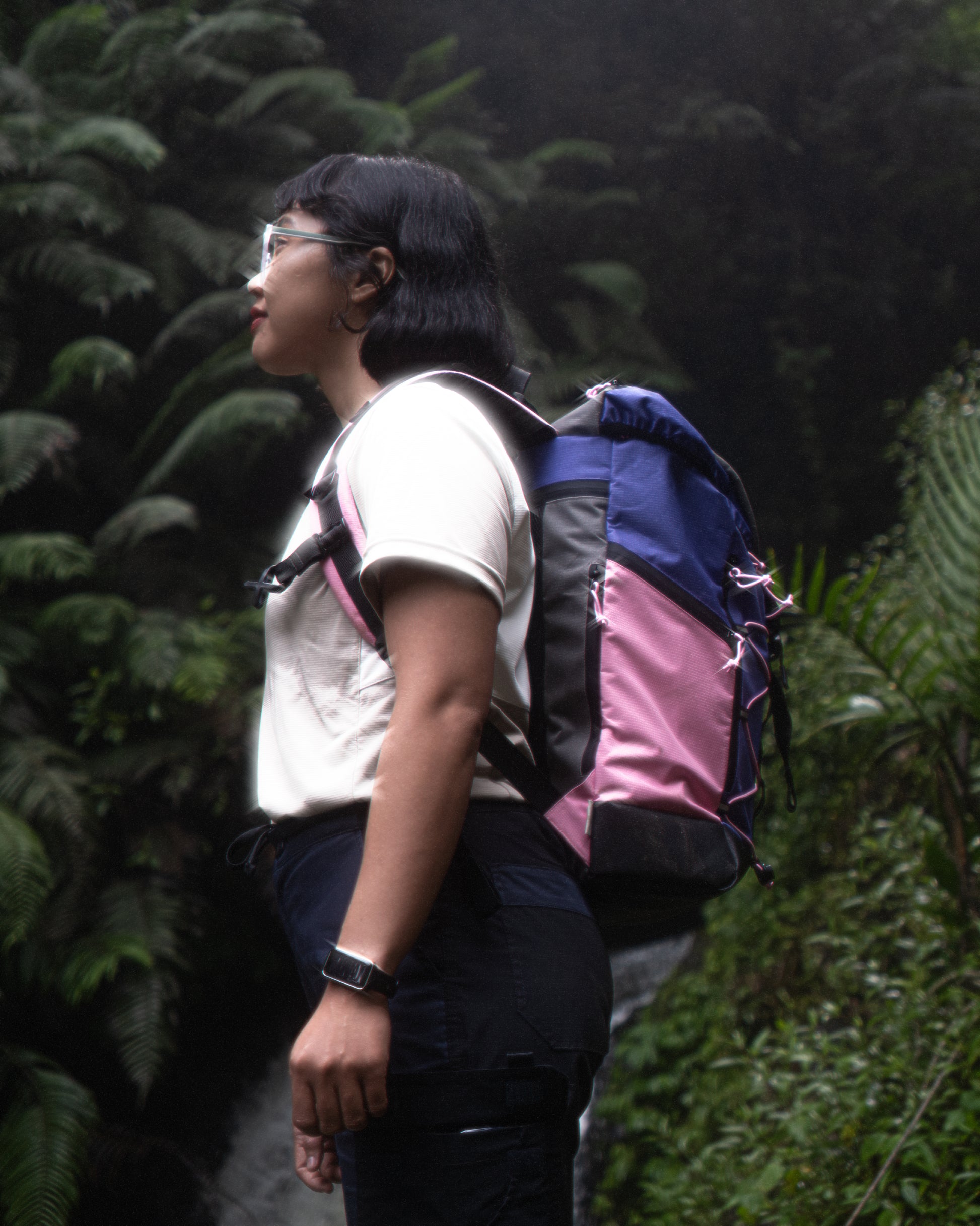 Profile view of a person wearing the TREQ WILDFLARE Trail 22L Outdoor Backpack in a forest setting, perfect for hiking and urban use.