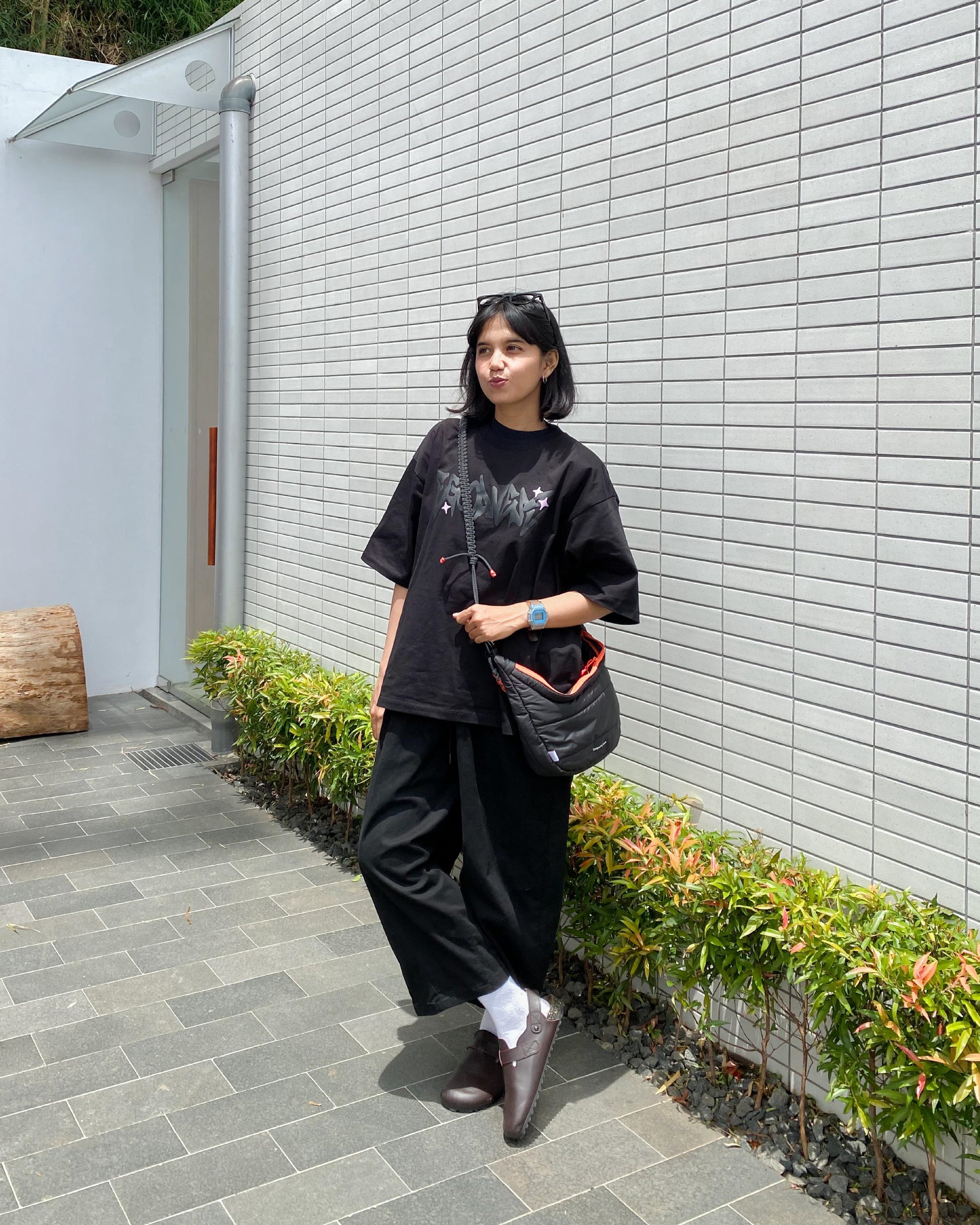 A casual image of a woman posing with the QUITAN Abyss Padded Crossbody Bag, perfect for fashion-forward individuals.