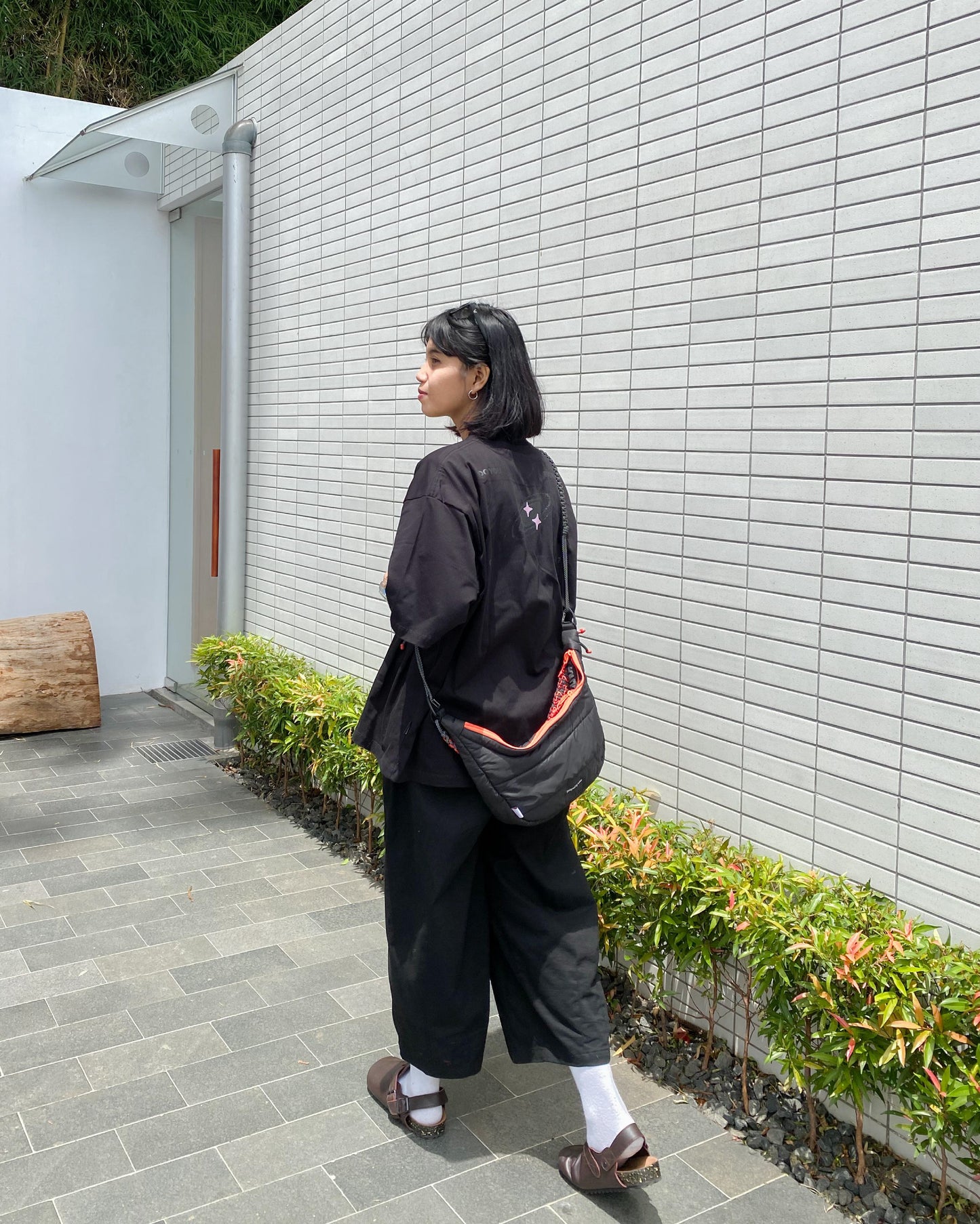 Rear view of a woman wearing the QUITAN Abyss Padded Crossbody Bag, emphasizing its stylish and practical design.